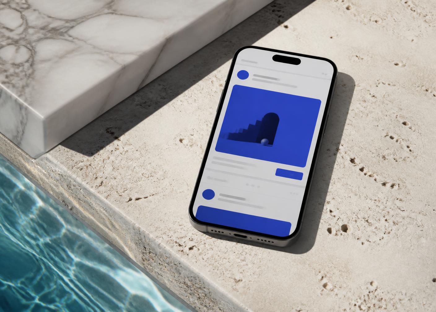 A smartphone showing a cobalt social advertising feed on travertine beside a pool